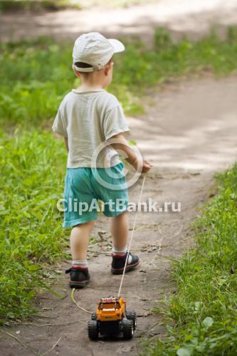 Маленький ребенок везет за собой машинку-ClipArtBank.ru-фотобанк,продажа лицензионных фотографий,изображений.Купить фотографию-М