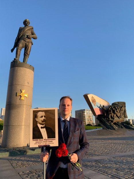 Автор статьи у Памятника героям Первой мировой войны с плакатом с фотографией своего прапрадеда Ивана Мартыновича Тамби (1876 — ок. 1919). Москва, Поклонная гора, 15 августа 2024 года. Источник: фотография из архива С. А. Тамби