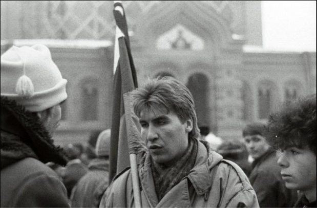 Тийт Тамби (крайний слева в светлой шапке с помпоном) интервьюирует представителя движения «Демократическая Россия» из Ленинграда, прибывшего на митинг, организованный Стачечным комитетом, Объединённым советом трудовых коллективов и Интерфронтом, чтобы выразить недоверие Правительству и Верховному Совету Эстонии в связи с повышением цен и налогов. Таллин, Замковая площадь, 15 января 1991 г. Фото: У. Ойястэ. Источник: Rahvusarhiivi filmiarhiiv. EFA.333.0.149072