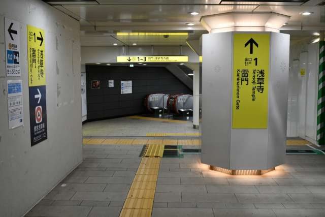 Тактильная плитка на станции метро Токио. На фото видны ярко-жёлтые полосы тактильной плитки на полу, ведущие от платформы к выходу и лифту. Такие элементы установлены на всех основных станциях, что помогает людям с нарушениями зрения безопасно ориентироваться в пространстве